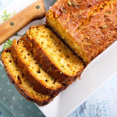 Cake à la feta, au coulis de tomates et au basilic présenté dans un plat, avec des tranches découpées
