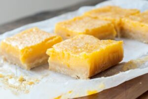 Yuzu bars, tarte au yuzu découpées en carrés et saupoudrée de sucre glace.