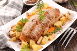 Rôti de veau au four servi avec des pommes de terre et des carottes