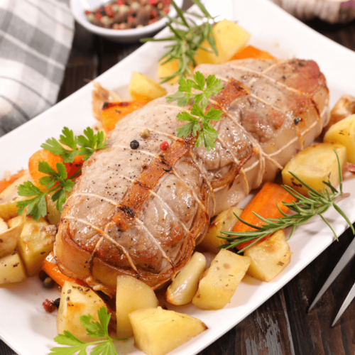 Rôti de veau au four servi avec des pommes de terre et des carottes