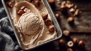 Glace à la noisette dans un bac de sorbet, avec des noisettes entières et concassées