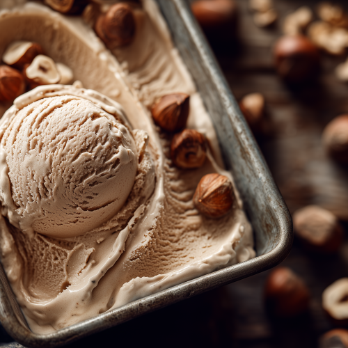 Glace à la noisette dans un bac de sorbet, avec des noisettes entières et concassées