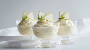 Mousse à la poire et au fromage blanc dans des coupelles avec des tranches de poires fraîches
