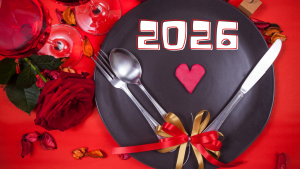 Saint Valentin 2026, dîner en amoureux, table dressée avec une belle assiette noire, une nappe rouge, des couvers, et un coeur rouge sur l'assiette