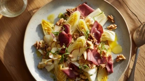 Salade d'endives aux magrets canard servie avec des noix et des morceaux de pommes