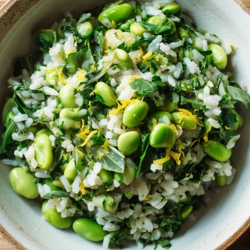 Salade de riz aux fèves et aux épinards servie dans un bol avec des herbes fraîches