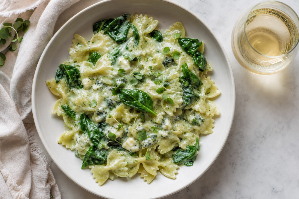 Bol de farfalles crémeuses aux épinards et gorgonzola, avec une fourchette à côté